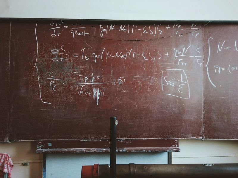 Pizarra antigua llena de fórmulas matemáticas escritas a tiza