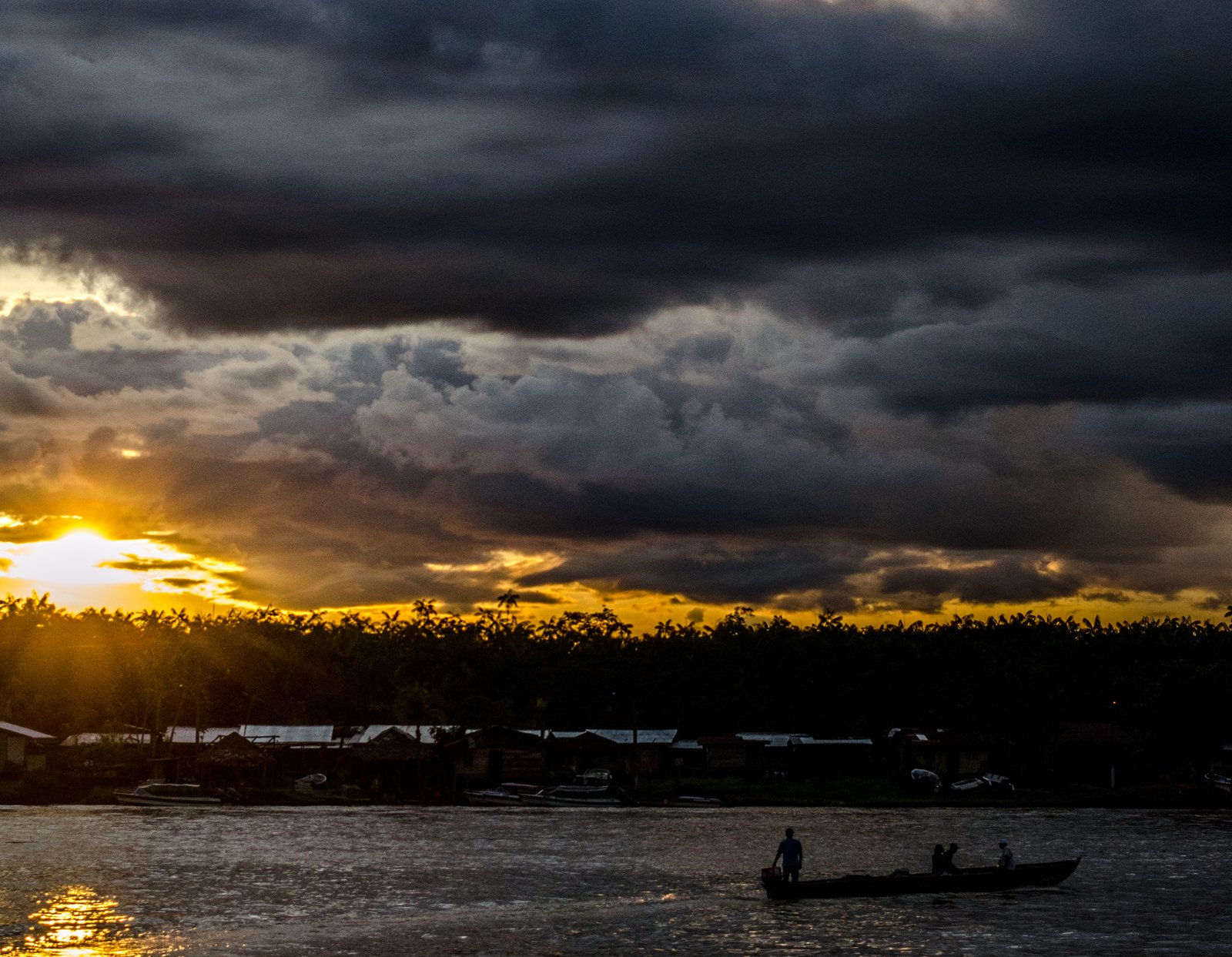 Atardecer sobre un río en Quibdó, Chocó, con una lancha en primer plano