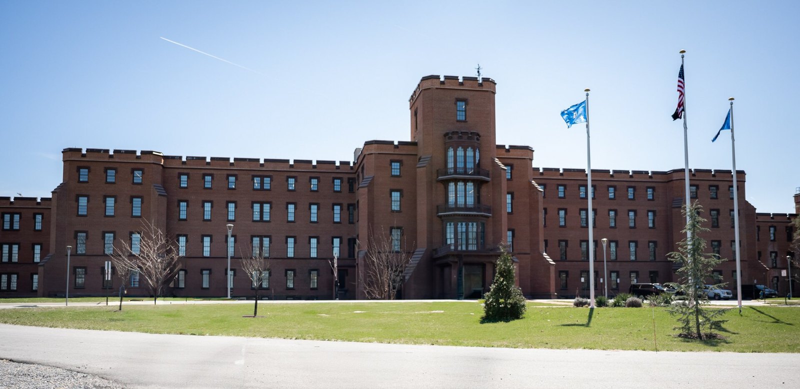 Edificio 1 del campus St. Elizabeths en Washington, sede de las oficinas ejecutivas del Departamento de Seguridad Nacional, con banderas frente a la fachada de ladrillo
