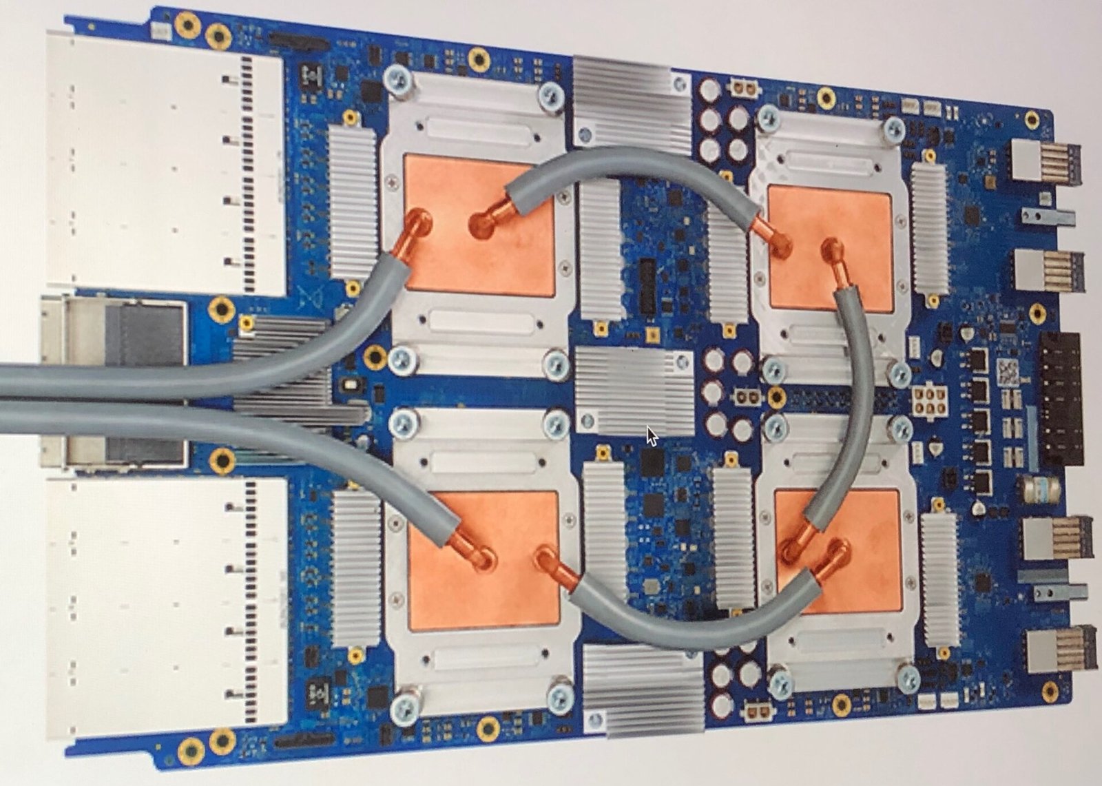 Placa de una unidad de procesamiento tensorial TPU 3.0 de Google con cuatro chips bajo bloques de refrigeración líquida conectados por tubos