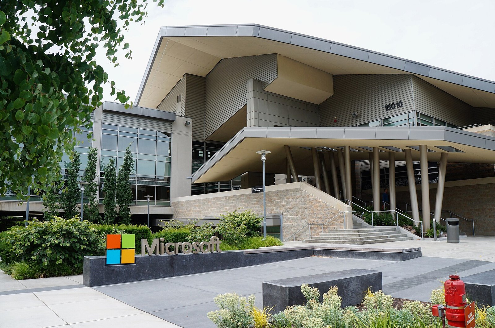 Edificio 92 del campus de Microsoft en Redmond, con el logotipo de la empresa sobre un muro bajo en primer plano