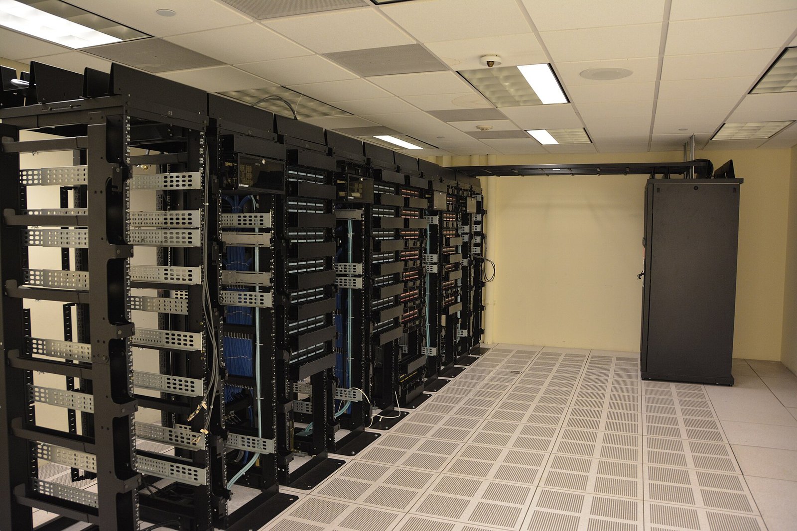 Fila de bastidores de servidores en un centro de datos con suelo técnico elevado