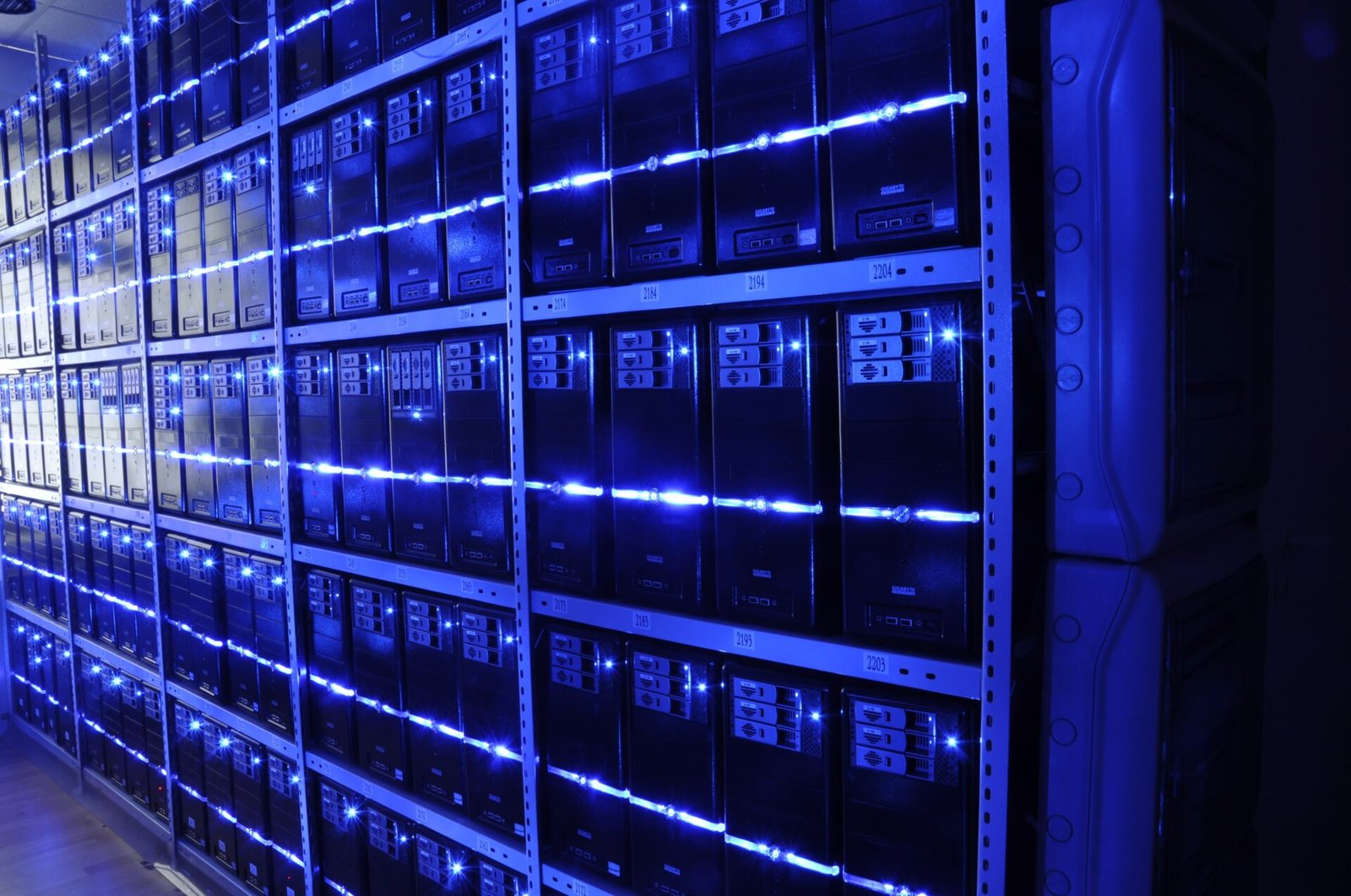 Sala de servidores con filas de racks iluminados en un centro de datos