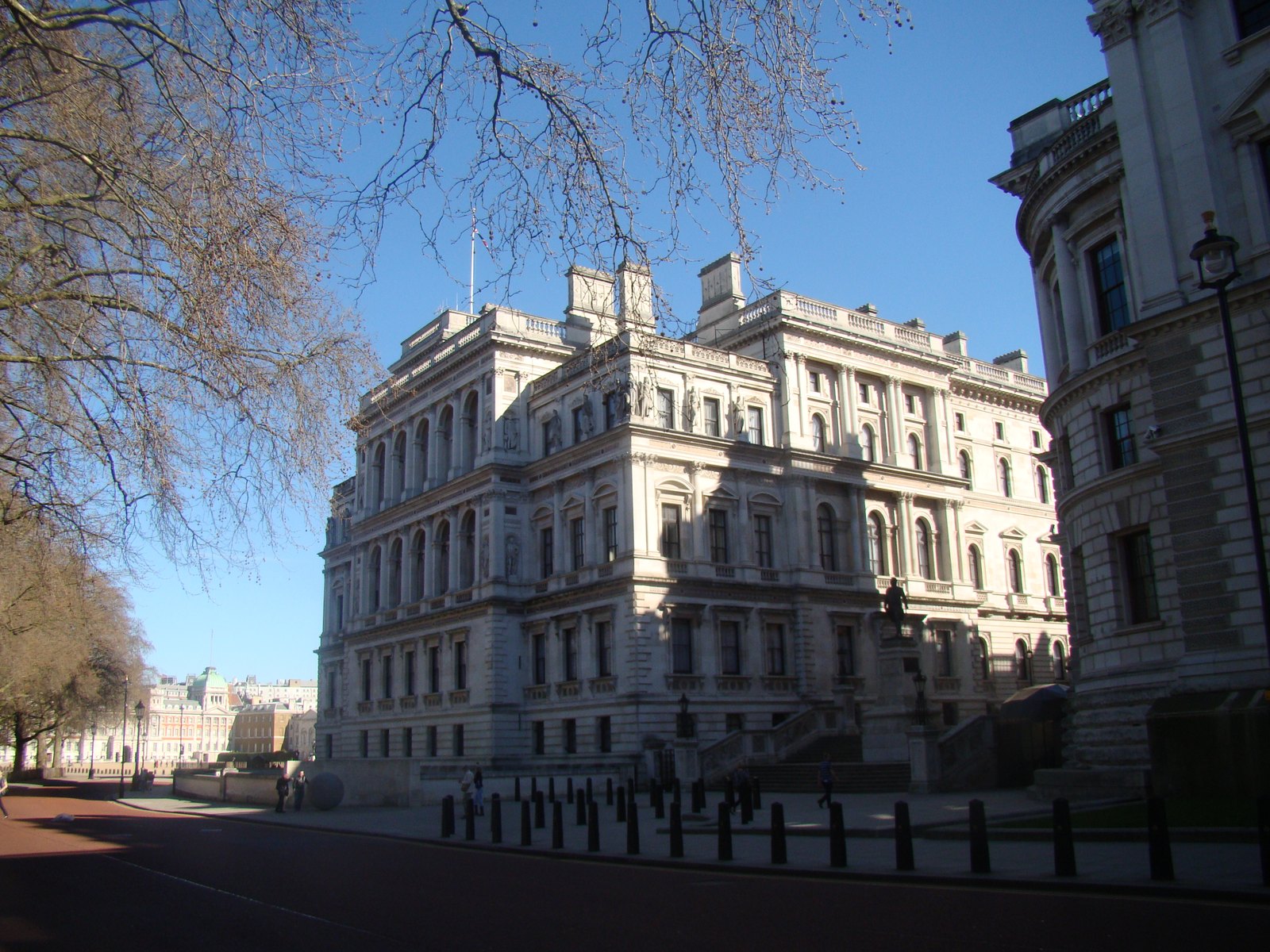 Fachada del edificio del Tesoro británico vista desde Horse Guards Road, en Londres, con árboles sin hojas en primer plano